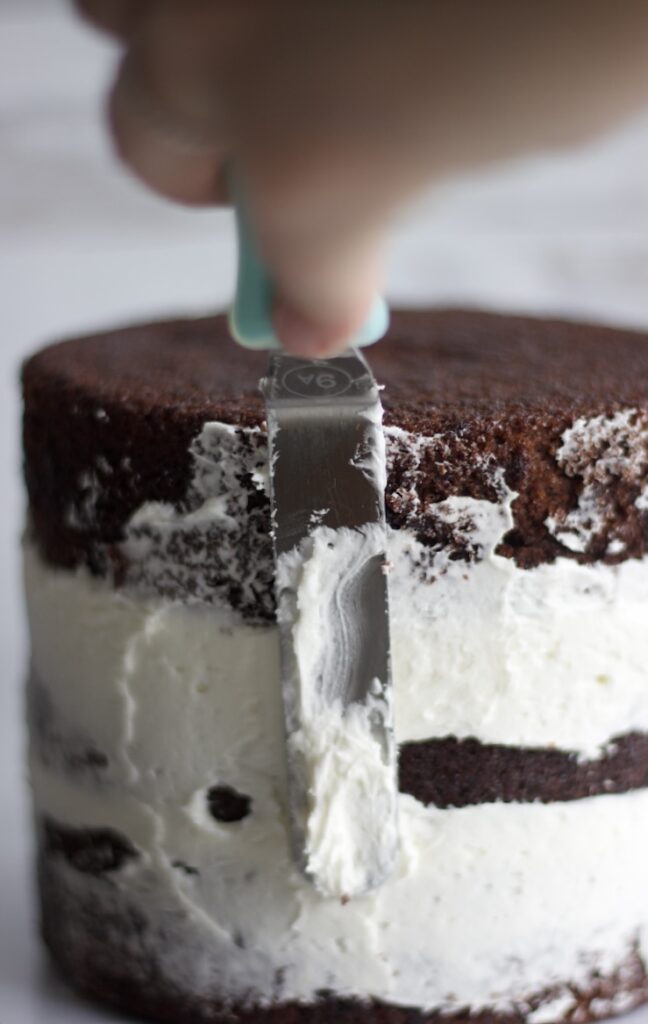 a cake being frosted to show how to make a cake more moist