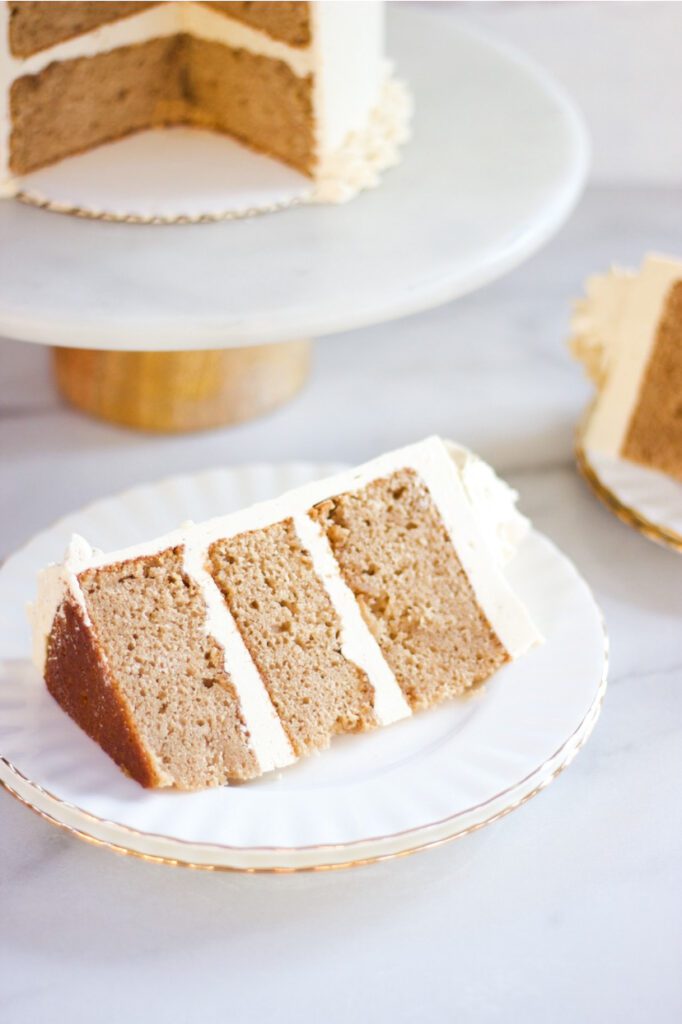Slice of Chai Cake on a white and gold plate.