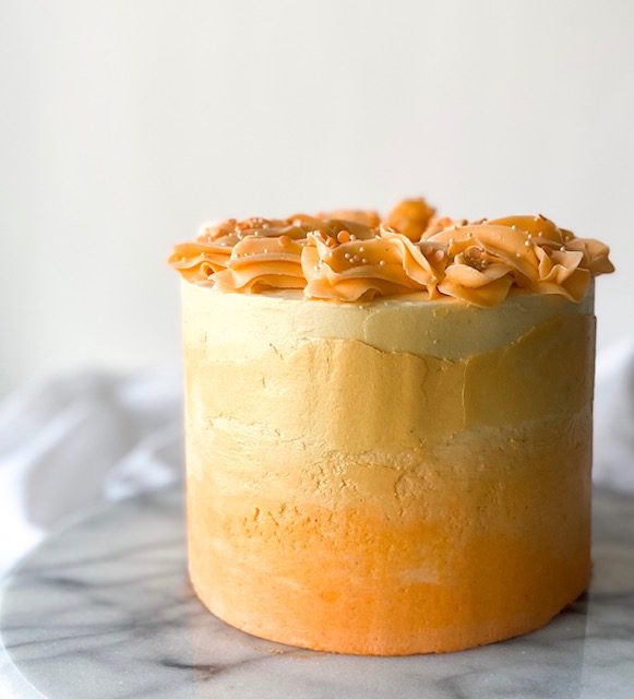 Easy Pumpkin Cake with orange frosting on a marble counter
