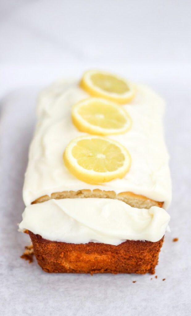 Luscious Lemon Loaf Cake with lemon slices on top sitting on a counter