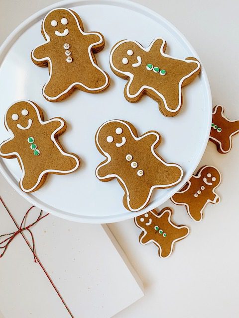gingerbread man cookies on a white plate with frosting on them