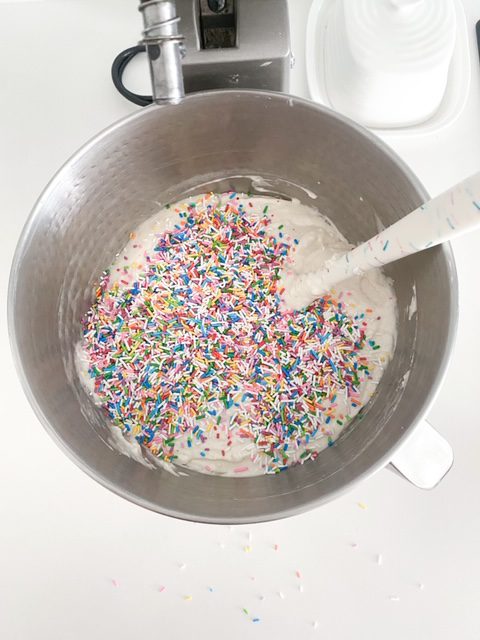 cake batter in a mixer bowl with sprinkles