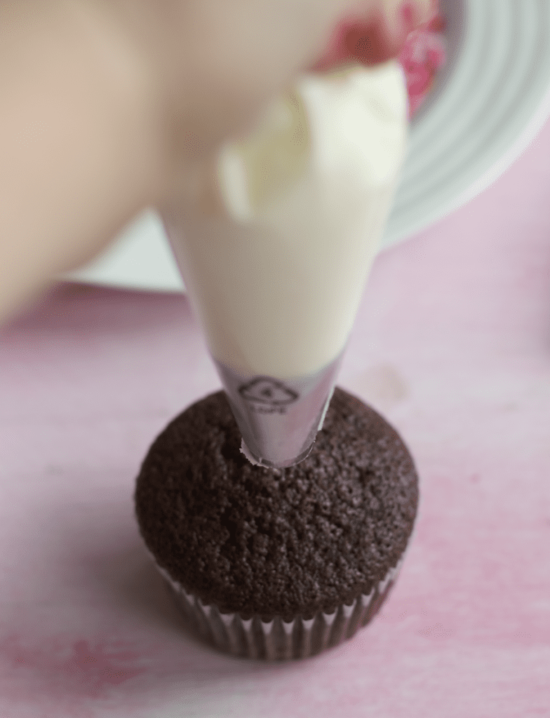 piping buttercream on a cupcake