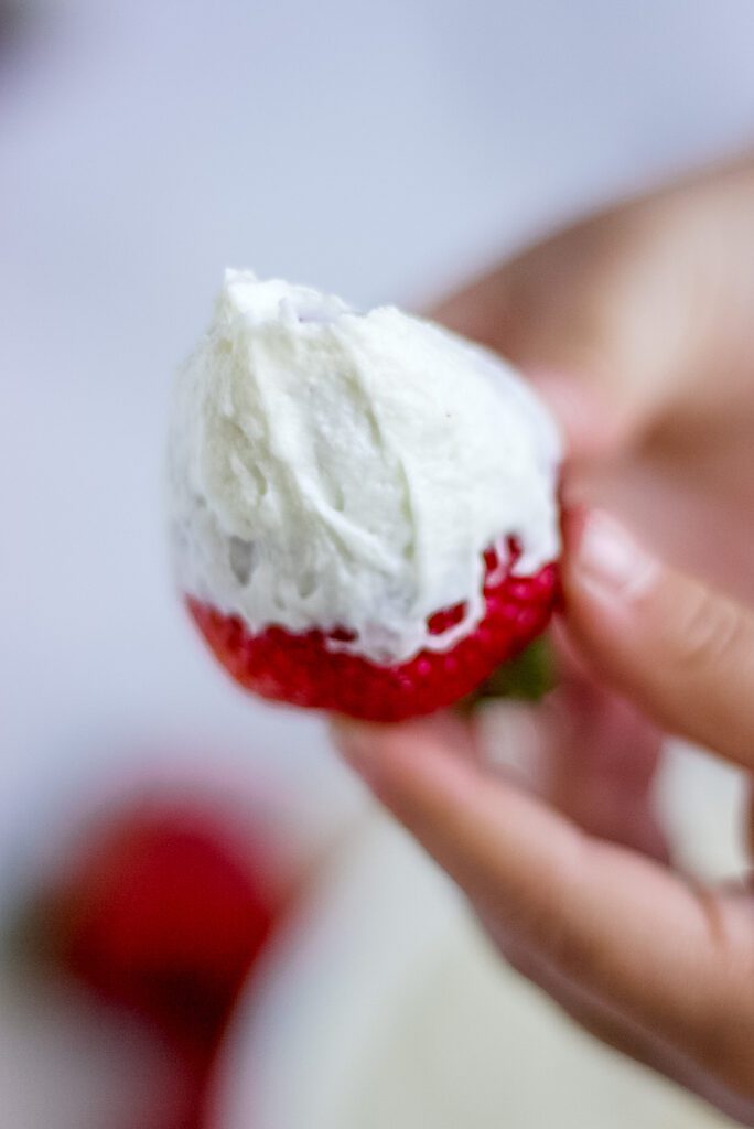 a strawberry in marshmallow fluff dip