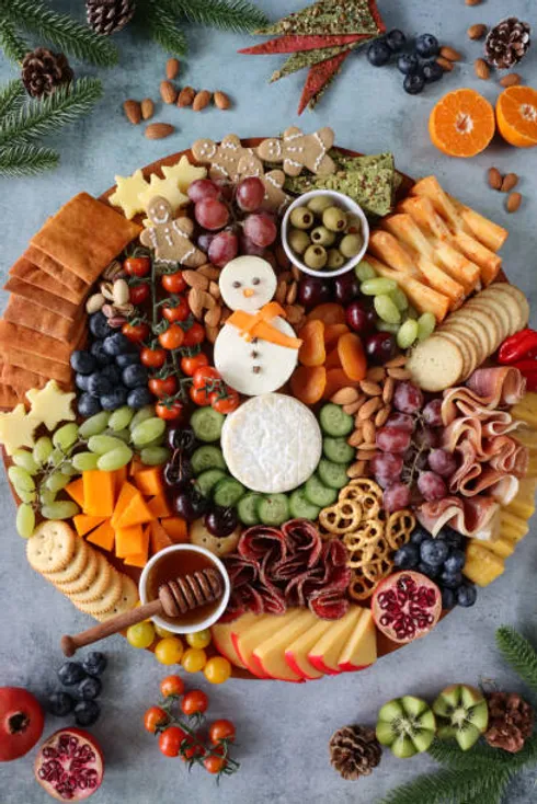 christmas charcuterie board with a cheese snowman