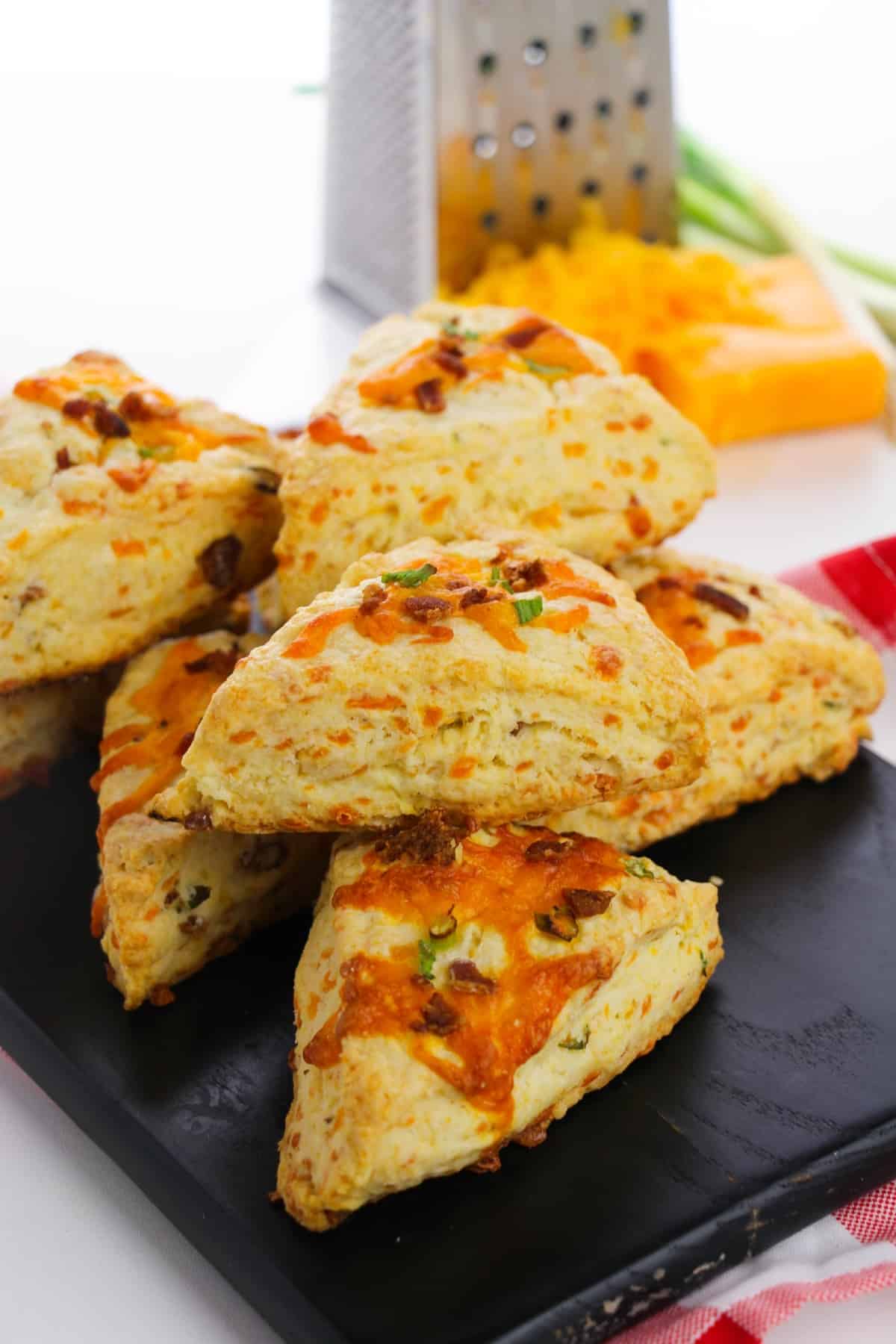 foolproof scones recipe for cheddar barcon scones that are stacked on a plate