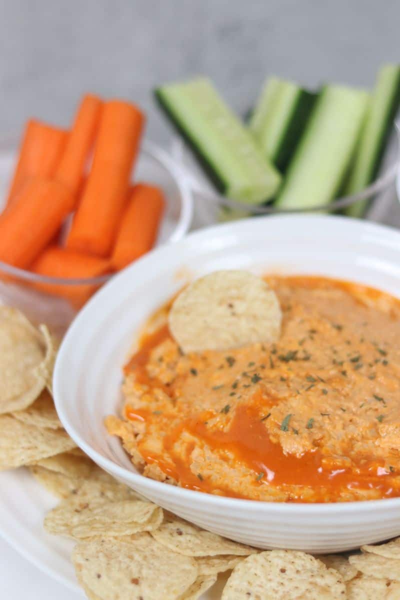 buffalo chickpea dip in a bowl with vegetables on the side