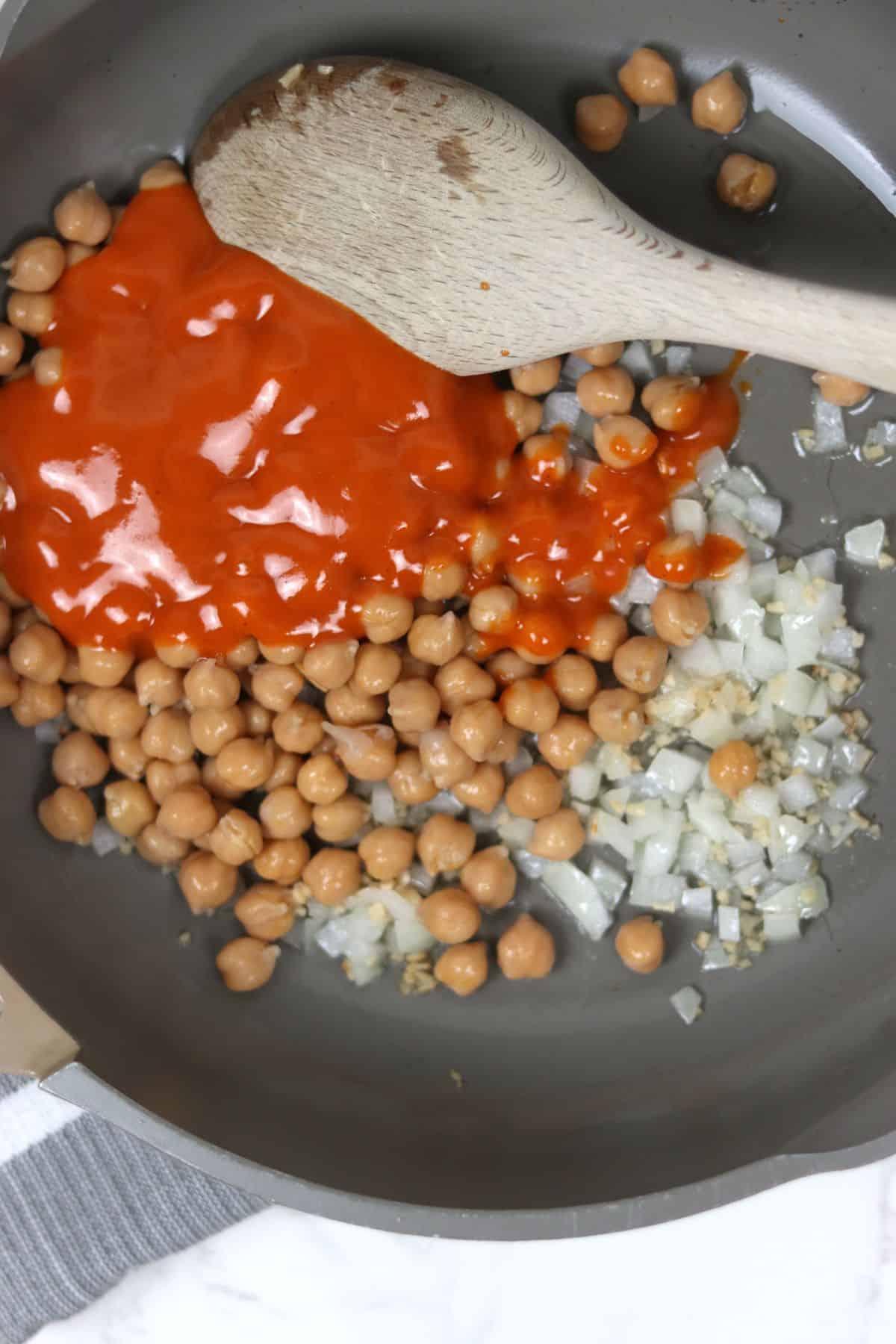 fry pan with ingredients to make buffalo chickpea quesdillas