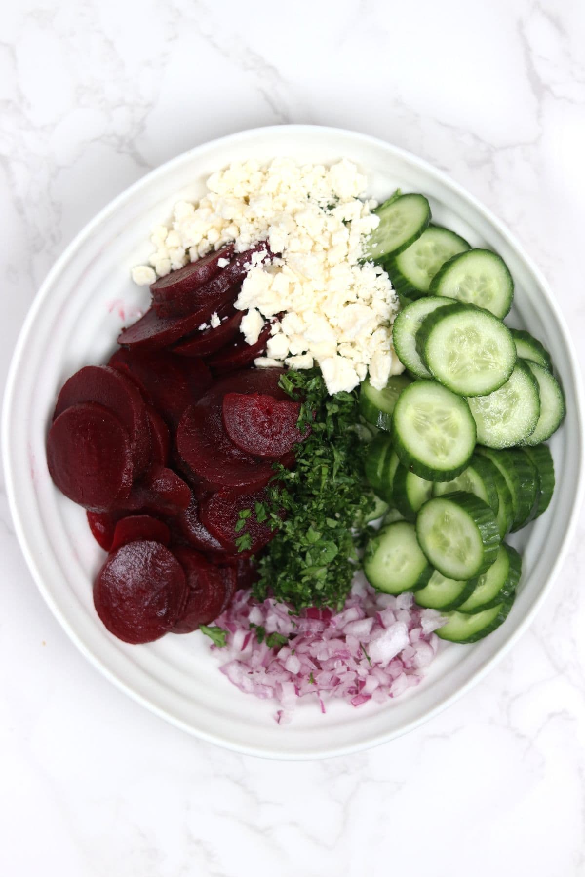 ingredients all in a bowl for cucumber beetroot salad