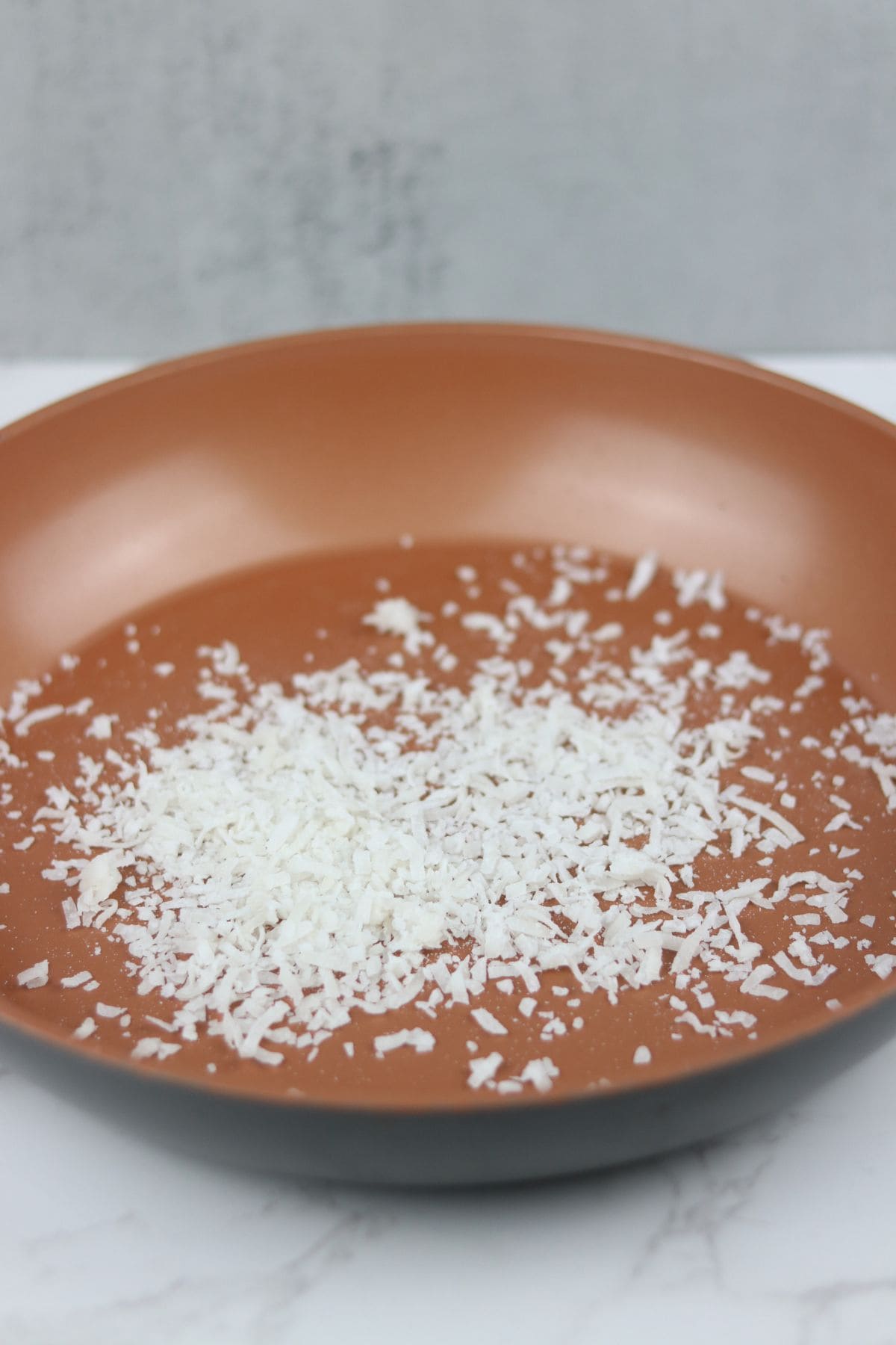 shredded coconut in a frying pan ready for toasting