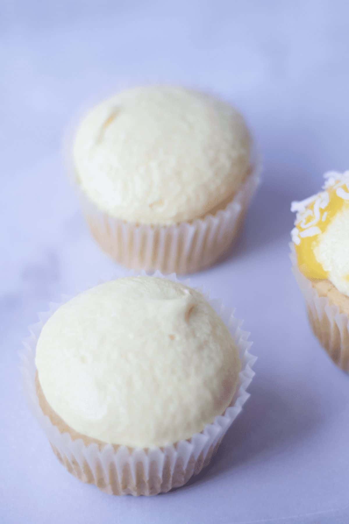 mango cupcakes with frosting on top