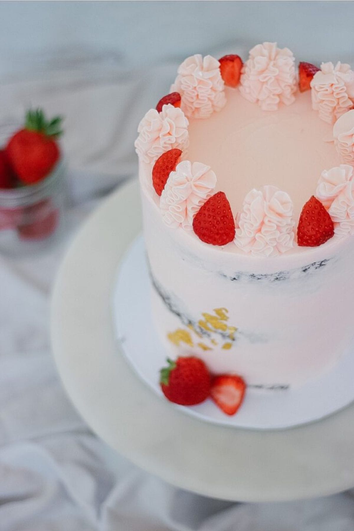 showing the top of the rose buttercream cake with strawberry pieces on top