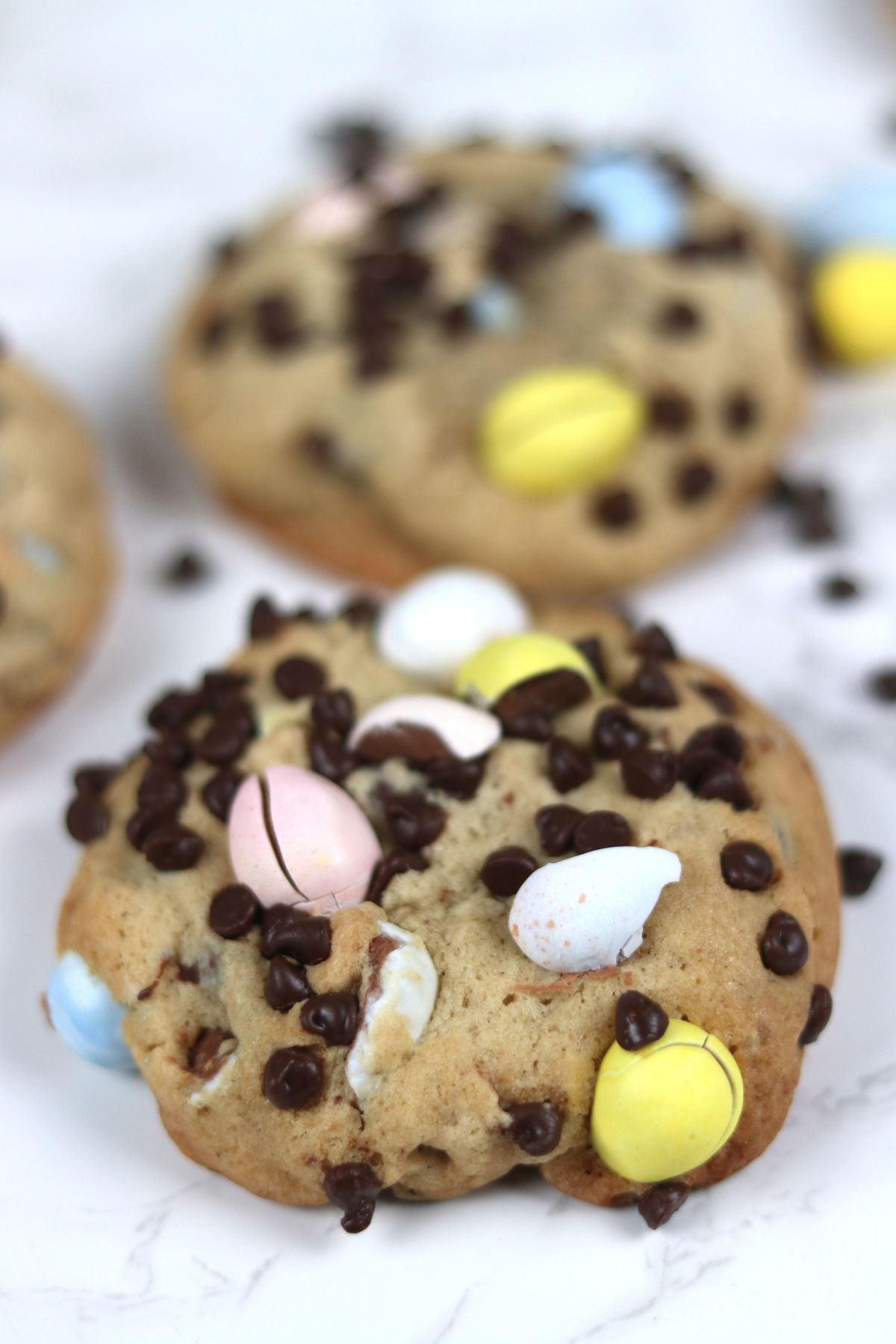 cadbury mini eggs cookie on a plate with chocolate chips around it